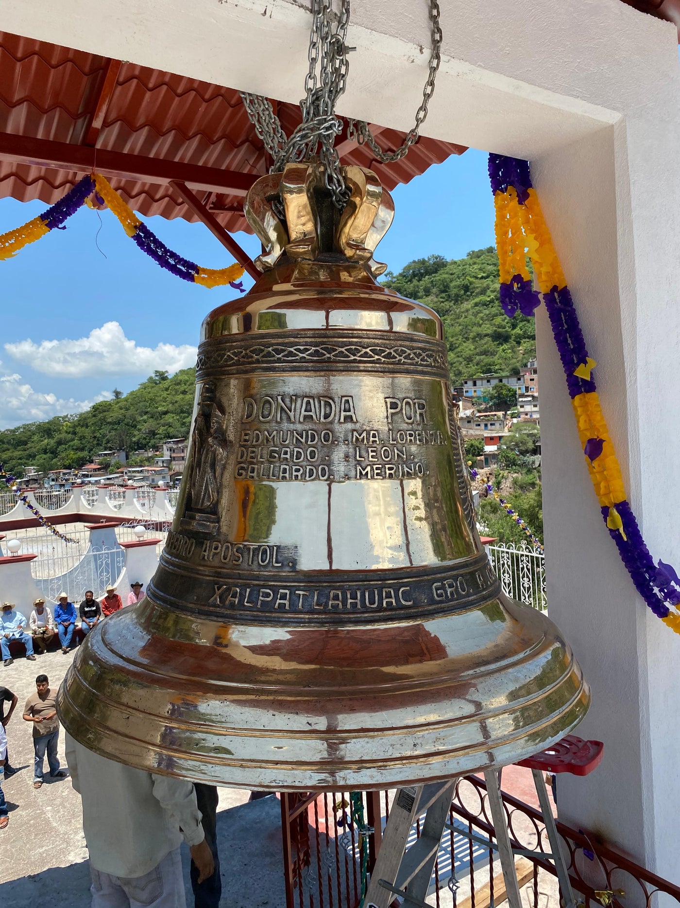 Campana de bronce donada con inscripción Donada por, instalada en el campanario de una iglesia