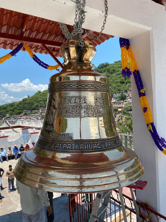 Campana de bronce donada con inscripción Donada por, instalada en el campanario de una iglesia