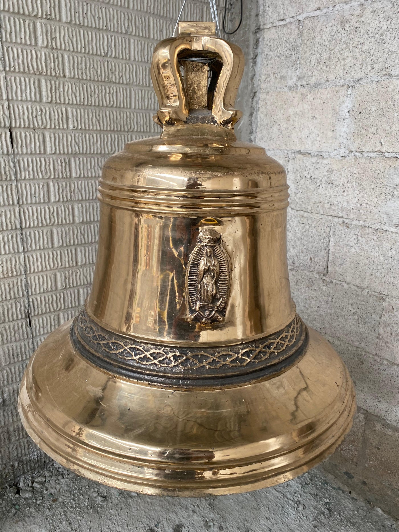 Campana de bronce pulido de Artesanías Jiménez con relieve de la Virgen de Guadalupe